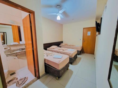 a room with two beds and a mirror at Portal Palace Hotel in Aparecida