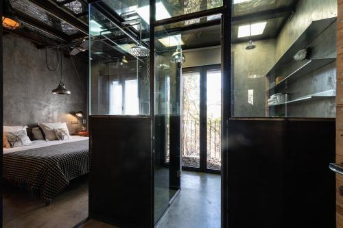 a bedroom with a bed and a glass wall at Retiro Park Industrial House in Madrid