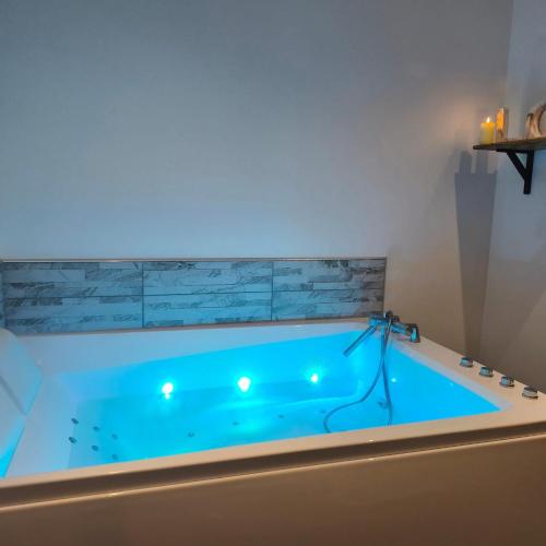 a large blue tub with lights in a bathroom at Ô Chalet Normand in Colomby
