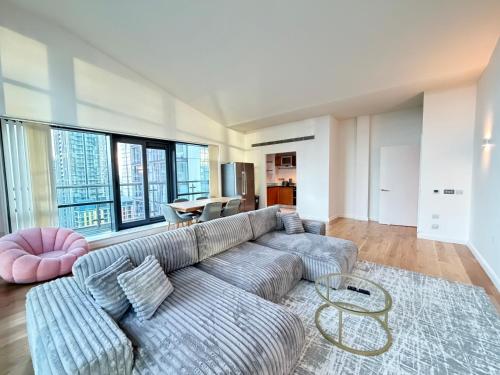a living room with a couch and a table at Horizon Canary Wharf Apartments in London