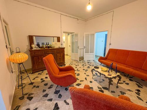 a living room with orange furniture and a mirror at B&B - Studio Arcodia in San Marco dʼAlunzio
