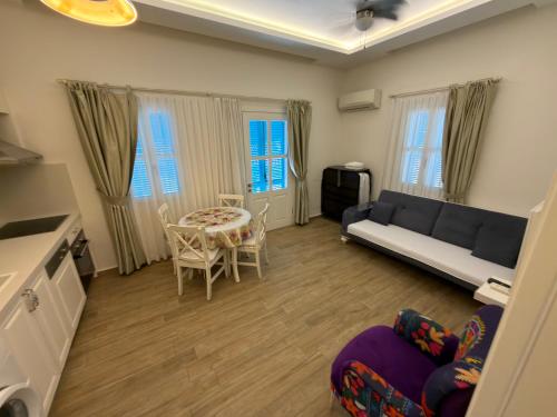 a living room with a couch and a table and chairs at Çeşme Kale Taş Apart in Çeşme