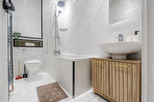 a white bathroom with a sink and a toilet at Exotic 4BD, Etihad, Coop Arena - TV in all Rooms and Outdoor Dining in Manchester