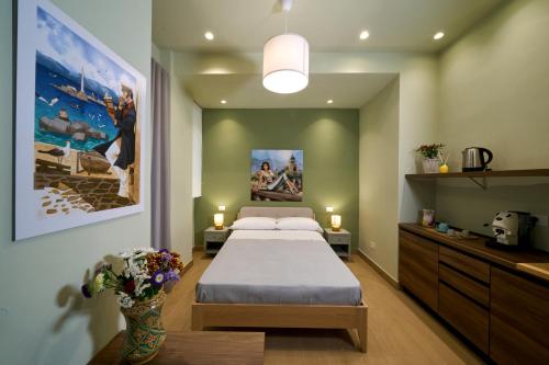 a bedroom with a bed and a large painting on the wall at Merlino Urban Suites in Messina