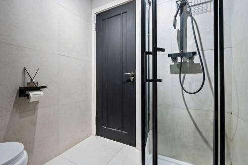 a bathroom with a shower with a black door at Luxury 2 Bed West London, Free Parking in Uxbridge