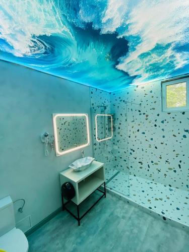 a bathroom with a wave painting on the ceiling at HOTEL MAREA NEAGRA Mamaia in Mamaia