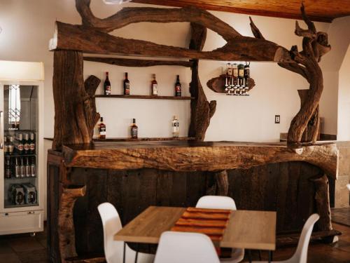 a dining room with a wooden table and chairs at Kudu Kopje Lodge in Kroondal