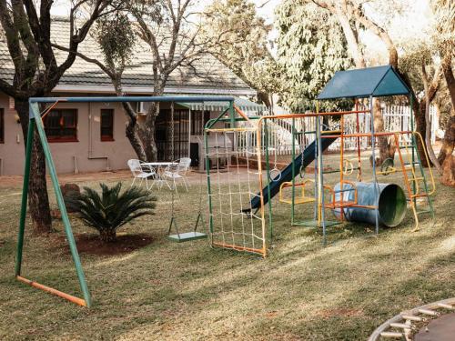 a playground in a yard with a slide at Kudu Kopje Lodge in Kroondal