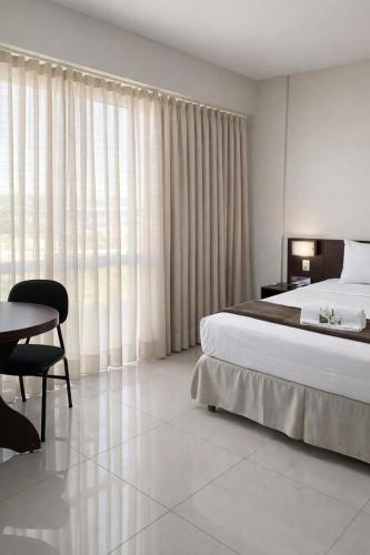a bedroom with a bed and a desk and a table at Atrium Express Hotels in Parauapebas