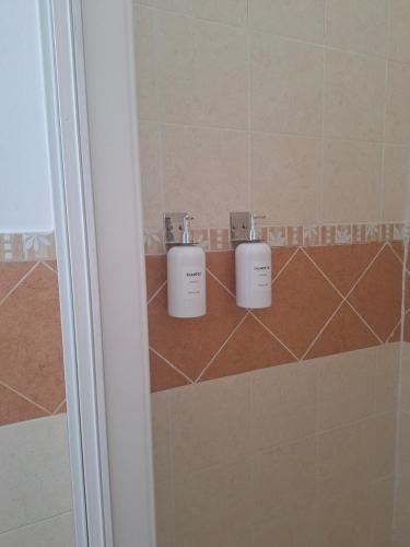 a bathroom with two soap dispensers on a tile wall at T2 Apart - Beach View - Santa Maria Center in Santa Maria