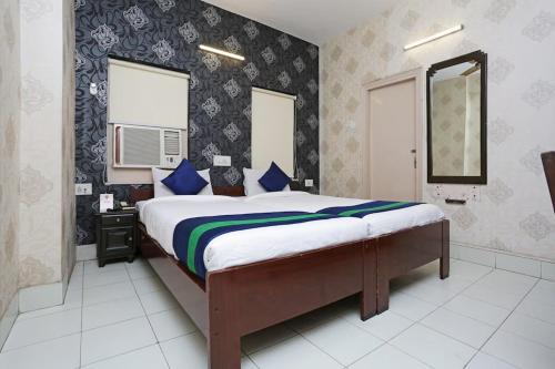 a bedroom with a large bed with blue pillows at Bengal Inn in Kolkata