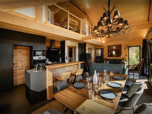 a dining room and kitchen with a table and chairs at Chalet L'Ursus - OVO Network in Gérardmer