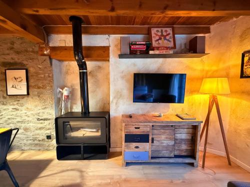 a living room with a stove and a tv at Casa Sinera - L'Amfitriona in Roní