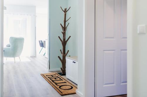 a room with a door and a tree in a rug at FeWo Lieblingsplatz in Zingst