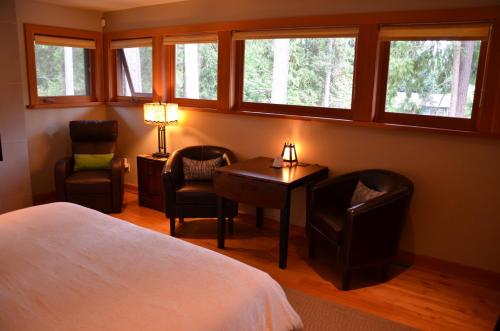 a bedroom with a bed and a table and chairs at Shades of Jade Inn & Spa in Roberts Creek