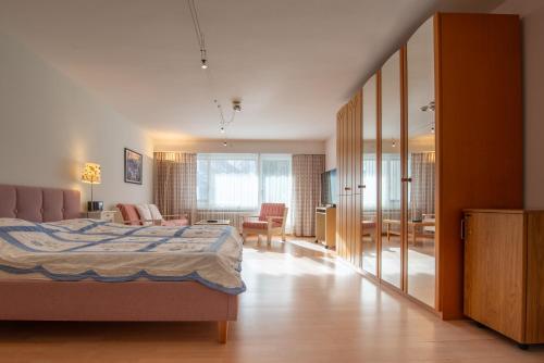 a bedroom with a bed and a living room at Badehotel Salina Maris – Wellness & Vintage in Mörel
