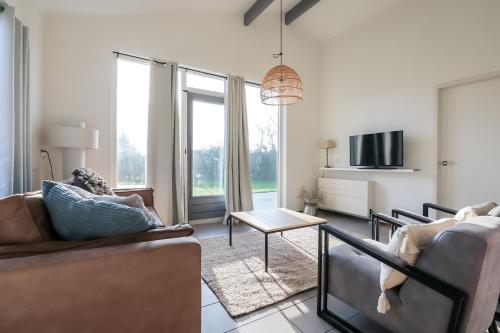 a living room with a couch and a table at Zilt vakantiehuisje - Rekerlanden 283 in Schoorldam