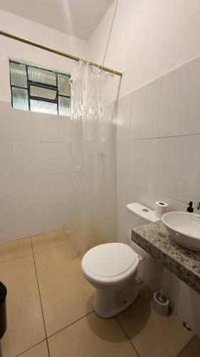 a white bathroom with a toilet and a sink at Casa Colina in Ouro Preto