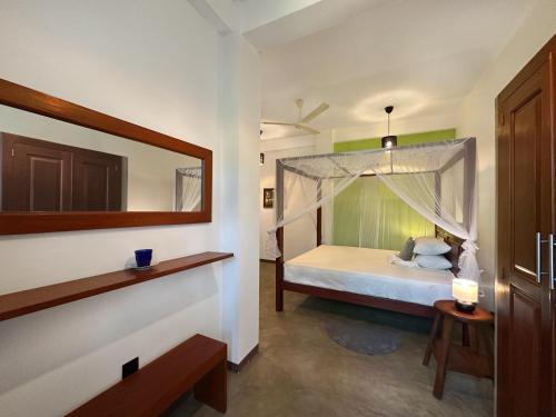 a bedroom with a bed with a canopy at Kumarana in Bentota