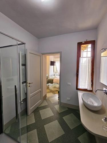 a bathroom with a sink and a glass shower at Villa Palazzo Delle Erbe in Casole dʼElsa