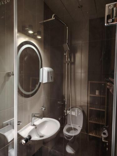 a bathroom with a sink and a toilet and a mirror at Mikado lounge in Itʼkhvisi
