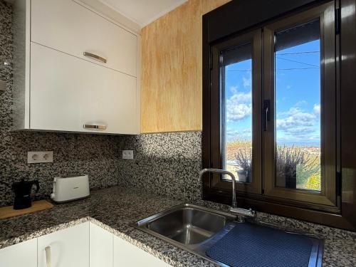 a kitchen with a sink and a window at YourHouse Casa Antonio in Sobrado del Obispo