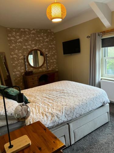 a bedroom with a bed and a mirror and a table at Morpeth, Northumberland home in Morpeth