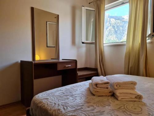 a bedroom with a bed and a mirror and towels at Apartmani OREBIĆ in Orebić