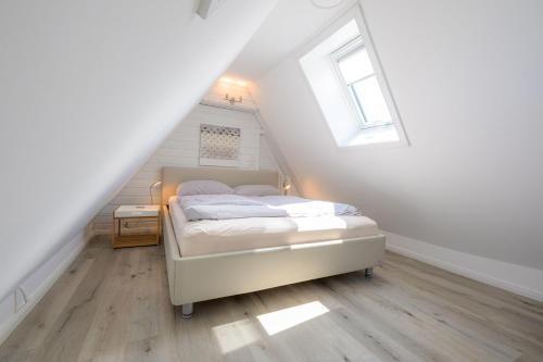 a bedroom with a bed in a attic at Ferienwohnung-NEU-Weidenstieg-OG in Wenningstedt