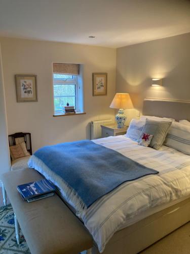 a bedroom with a large bed with a book on it at Brook Farm Cottage in Brackley