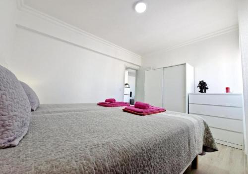 a bedroom with a bed with pink pillows on it at Blue Sun Armação in Armação de Pêra