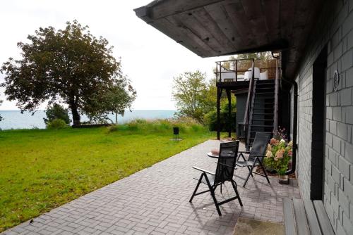 a patio with two chairs and a table on a house at Engure BeachHouse in Engure