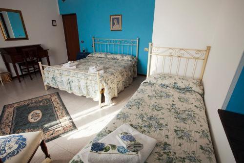 een slaapkamer met 2 bedden en een bank en een stoel bij Il Tugurio Agriturismo B&B in Rivotorto 