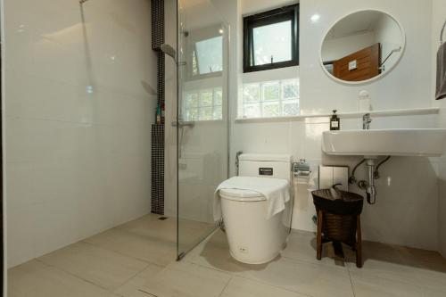 a bathroom with a toilet and a sink at Whisper Oasis - Award-Winning Private Jacuzzi Pool Villa - 3BR, Daily Service in Chiang Mai