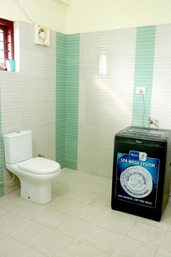 a bathroom with a toilet and a sign that says six west system at Dew Drops Inn kovalam in Kovalam