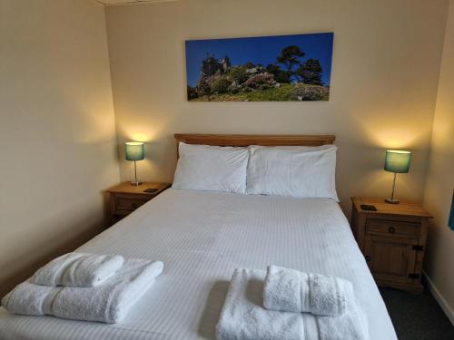 a bedroom with a bed with towels on it at Wheal Rodney Holiday Park in Marazion