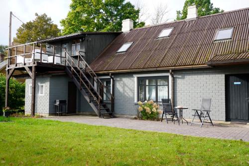 a house with a balcony and a table and chairs at Engure BeachHouse in Engure