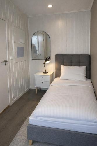 a bedroom with a large bed and a mirror at Arctic Sea Apartments in Hammerfest