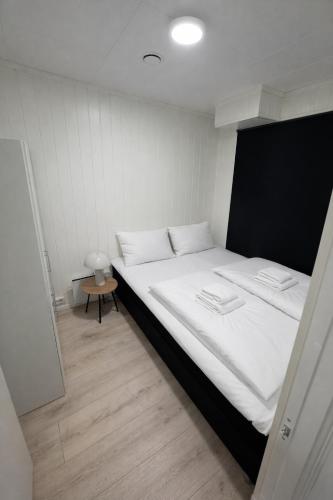 a bedroom with a large bed with white sheets at Arctic Sea Apartments in Hammerfest