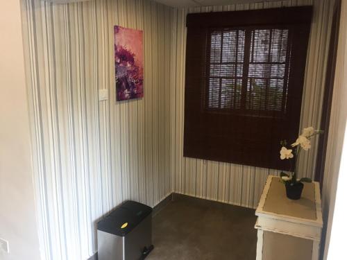 a room with a television and a window at Sinclair Guest House in Abuja