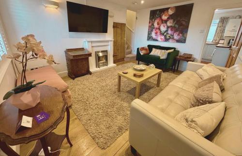 a living room with a couch and a fireplace at Quaint 2 bed Cottage in the Heart of Cambridge in Cambridge