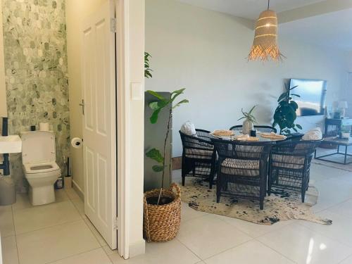 a dining room with a table and a toilet at Salt & Still in Freeland Park