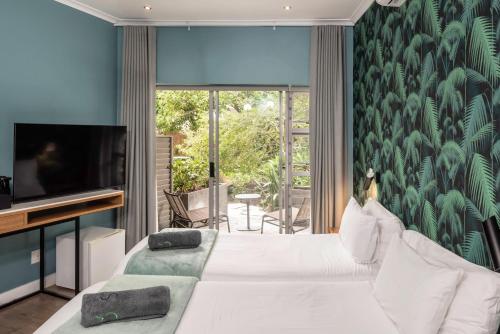 a bedroom with a white bed and a tv at Sovn Boutique Hotel in Cape Town