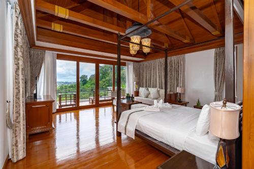 a bedroom with a large bed and a large window at Royal Legacy Golf Private Villa in Rawai Beach