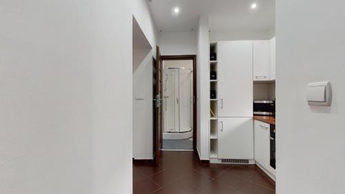 a kitchen with white cabinets and a hallway at Studio Fibra Doppio in Rybnik