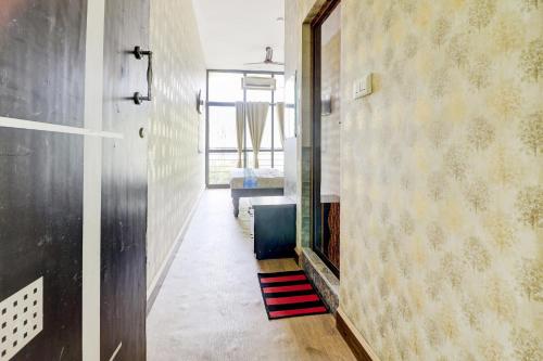 a hallway with a mirror and a room with a bed at Hotel O Together in Bangalore