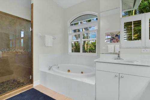 a white bathroom with a tub and a sink at Sunsets At Tiki Terrace in Cape Coral