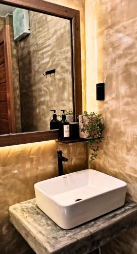 a bathroom with a white sink and a mirror at Terra Siargao in General Luna
