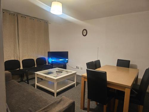 a living room with a table and a television at Happy Lodge Gillingam Kent in Gillingham