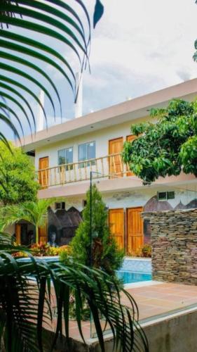 a building with a balcony and a swimming pool at Hostal Los Arhuacos in Santa Marta